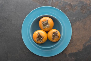 mavi tabak turuncu tüm persimmons üstten görünüm
