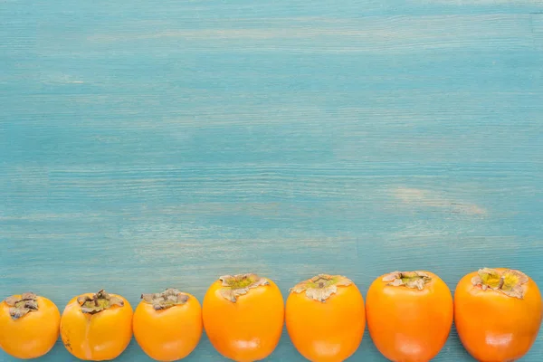 Flache Lage Von Persimmons Auf Blauem Hintergrund Mit Kopierraum — Stockfoto