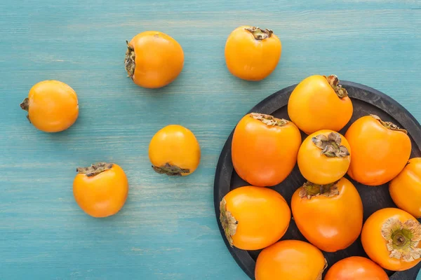 Top View Orange Ripe Persimmons Black Plate — Stock Photo, Image