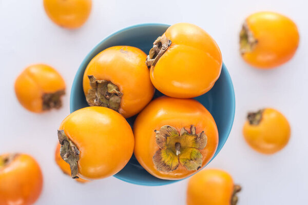 selective focus of ripe persimmons on blue glass plate