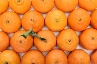 top view of whole ripe tangerines with green leaves on white background clipart