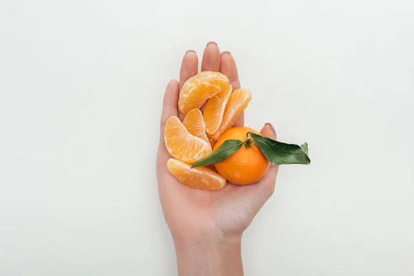 裁剪的妇女举行去皮的橘子片和整个橘子在白色背景上的看法 — 图库照片