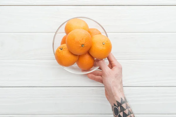 Beskuren Bild Mannen Hålla Glasskål Med Mogna Mandariner Träytan — Stockfoto