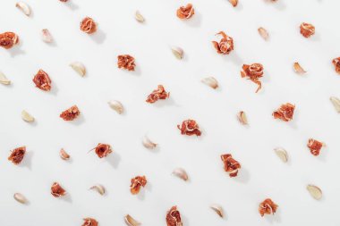 top view of prosciutto and garlic cloves on white background clipart