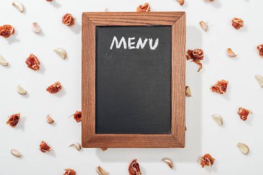 top view of chalk board with menu lettering among prosciutto and garlic cloves clipart