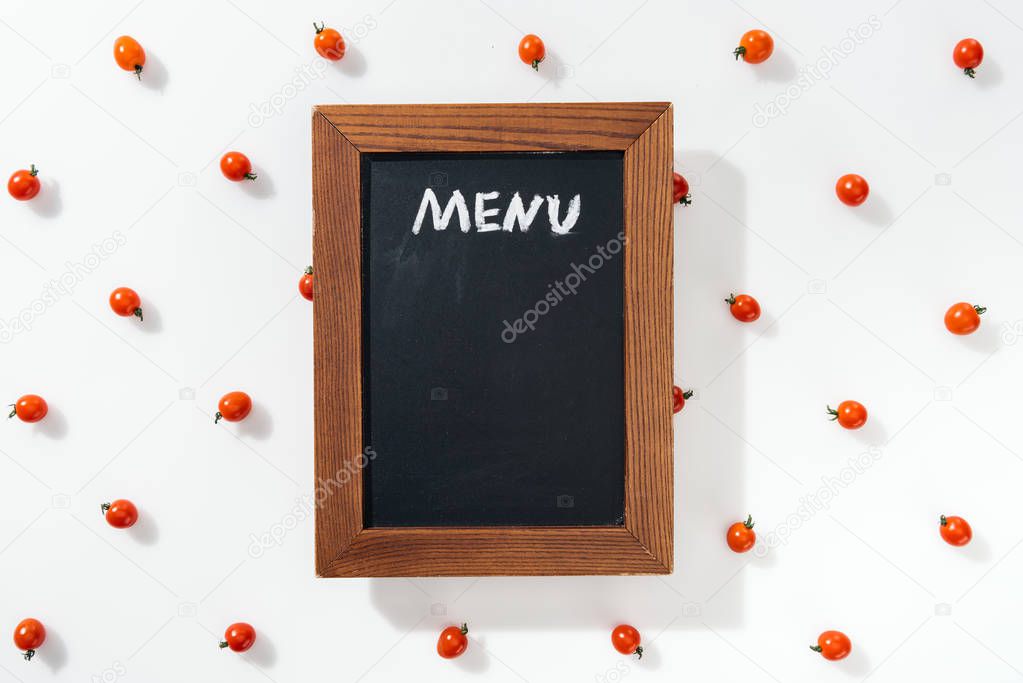 top view of chalk board with menu lettering among cherry tomatoes