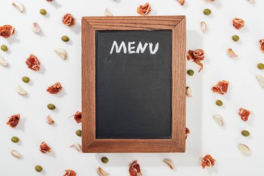 top view of chalk board with menu lettering among prosciutto, olives and garlic cloves clipart
