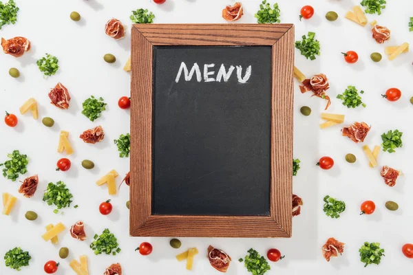 Top view of chalk board with menu lettering among olives, prosciutto, greenery, cut cheese and cherry tomatoes — Stock Image Top View Chalk Board Menu Lettering Olives Prosciutto Greenery Cut Stock Picture