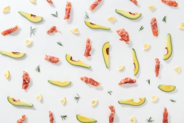 prosciutto dilimlenmiş avokado, limon ve biberiye twigs yakınındaki beyaz arka plan üzerinde yukarıdan