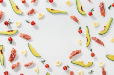 prosciutto dilimlenmiş avokado, limon ve beyaz zemin üzerine domates yakın düz lay