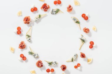 beyaz zemin üzerine mavi peynir ve biberiye dal yakınındaki jambon, domates ve mozzarella peyniri dilimlenmiş armut Üstten Görünüm