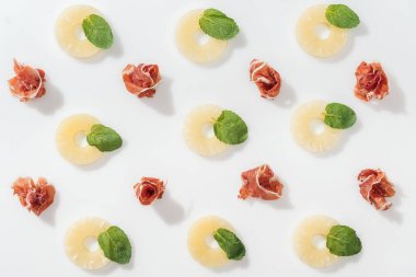 Yeşil fesleğen yaprakları ve ananas yüzük yakınındaki lezzetli prosciutto üstten görünüm beyaz arka plan üzerinde