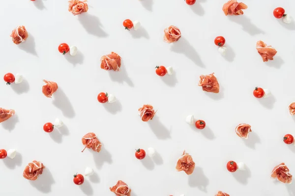 Kırmızı Kiraz Domates Yakınındaki Ham Prosciutto Üstten Görünüm Beyaz Arka — Stok fotoğraf