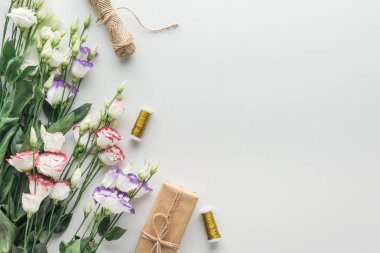 gri arka plan üzerinde eustoma, sarılmış hediye, sicim ve iş parçacığının biriktiricileri Üstten Görünüm