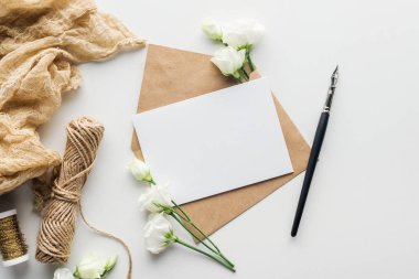 gri arka plan üzerinde eustoma, kumaş, zarf boş kart ve mürekkep kalemle Üstten Görünüm