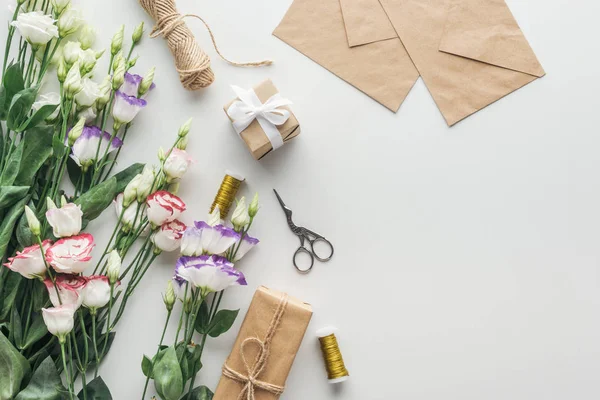 Top View Eustoma Wrapped Gifts Spools Thread Envelopes Scissors Grey — Stock Photo, Image