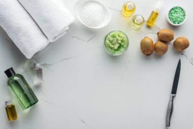 Kozmetik, havlu ve beyaz yüzeyinde kozmetik şişe yapmak için farklı malzemeler Üstten Görünüm