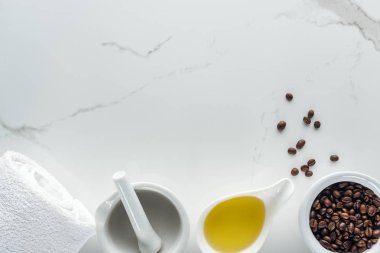 Top pounder görünümünü, havlu, kase kahve taneleri ve beyaz yüzeyindeki yağı ile