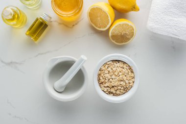 kase yulaf gevreği, pounder, limon ve ev yapımı kozmetikler için çeşitli bileşenleri ile üstten görünüm beyaz yüzeyi