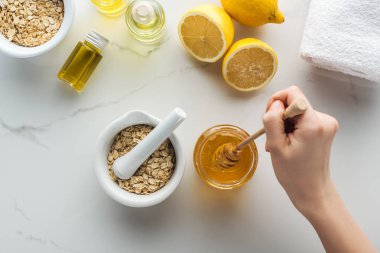 Tatlım sopa ile el, pounder yulaf gevreği, limon ve farklı doğal maddeler ile kısmi görünümünü beyaz yüzeyi