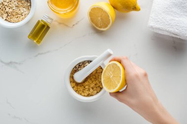 yarım limon ile el ve karışık yulaf gevreği ve ballı pounder kısmi görünümünü beyaz yüzeyi