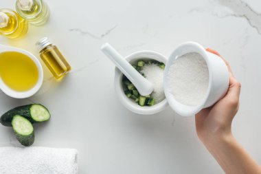 kadının pounder kesilmiş salatalık beyaz yüzeyi ile içine tuz ekleyerek kısmi görünümü