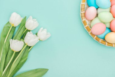 hasır plaka üzerinde mavi izole üstten görünüm beyaz laleler ve Paskalya yumurta 
