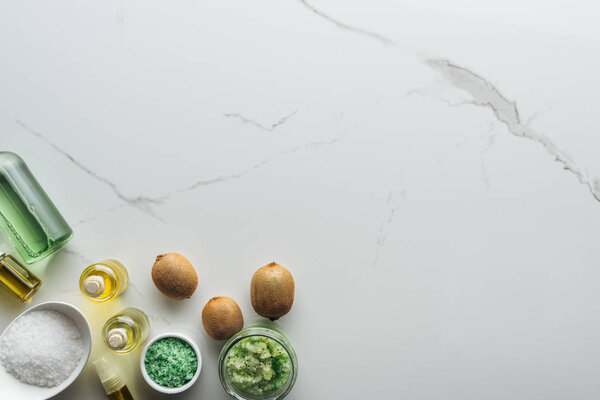 вид сверху на различные компоненты для домашней косметики и косметические бутылки на белой поверхности
 