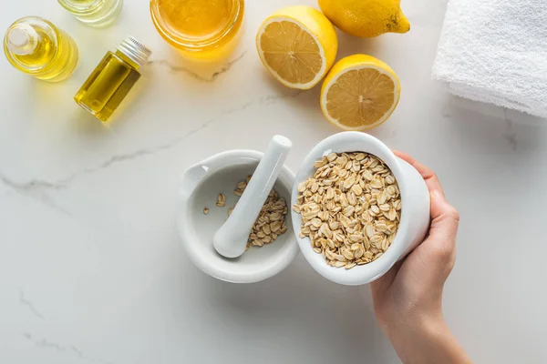 Cropped View Woman Pouring Oat Flakes Pounder White Surface — Stock Photo, Image