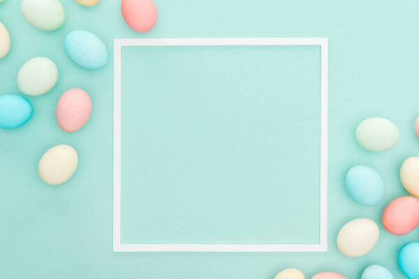 top view of traditional easter eggs near empty frame isolated on blue