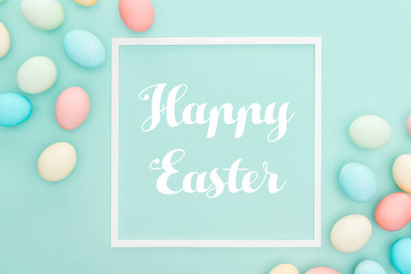 top view of traditional painted eggs with Happy easter lettering in frame isolated on blue