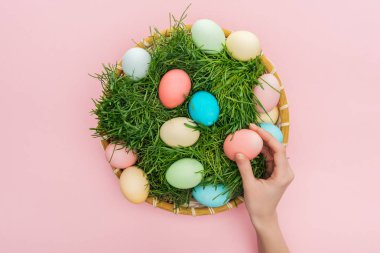 kırpılan pastel Paskalya yumurtaları pink izole ot ile hasır plaka ile el görünümünü 