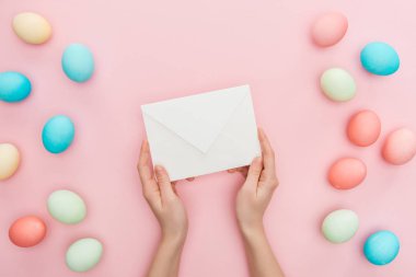 Kısmi görünümünü pembe pastel Paskalya yumurtaları ile izole zarf tutan kadın 