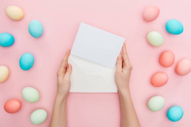 kırpılan eller tebrik kartı ve pembe pastel Paskalya yumurtaları ile izole zarf görünümünü 