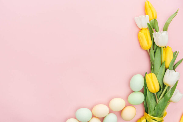 top view of tulips and pastel easter eggs isolated on pink
