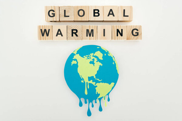 paper cut melting sign and "global warming" lettering on wooden cubes on grey background 