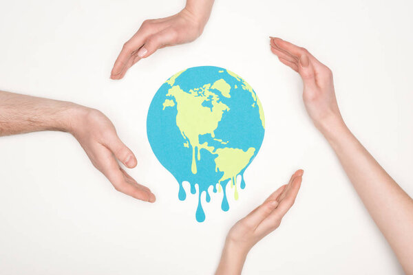 partial view of male and female hands around paper cut melting globe on white background, global warming concept