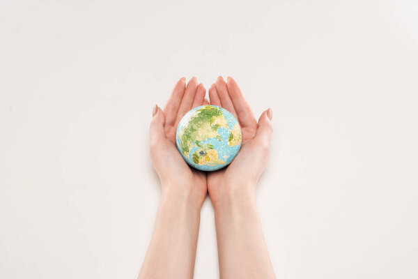 cropped view of female holding earth model on white background, global warming concept