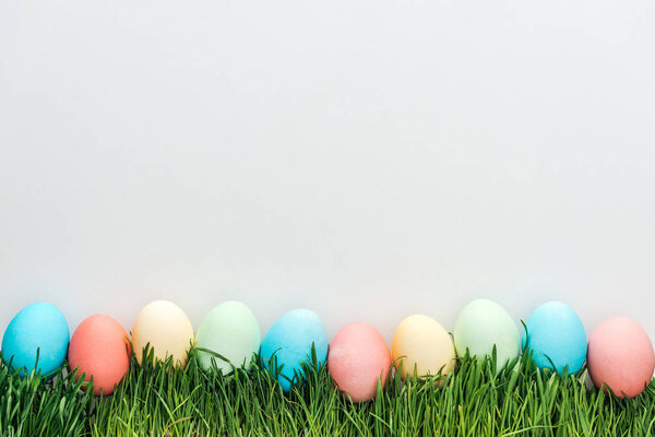 top view of traditional easter eggs on grass isolated on grey 