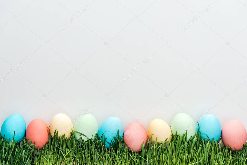 top view of traditional easter eggs on grass isolated on grey 
