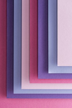 Mavi, beyaz, pembe ve mor kağıda üstten görünüm pembe bir arka plan üzerinde 