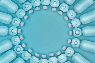 plastik su şişeleri üzerinde kopya alanı ile turkuaz izole yapılmış yuvarlak çerçevenin Üstten Görünüm
