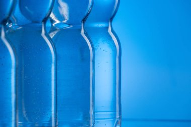 mavi arka plan kopya alanı ile satırda kabarcıkları ile plastik su şişe yakın çekim