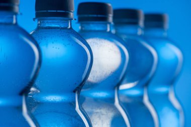 mavi arka plan üzerinde satır kabarcıkları ile plastik su şişe yakın çekim