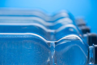 mavi arka plan üzerinde satır kabarcıkları ile plastik su şişe yakın çekim