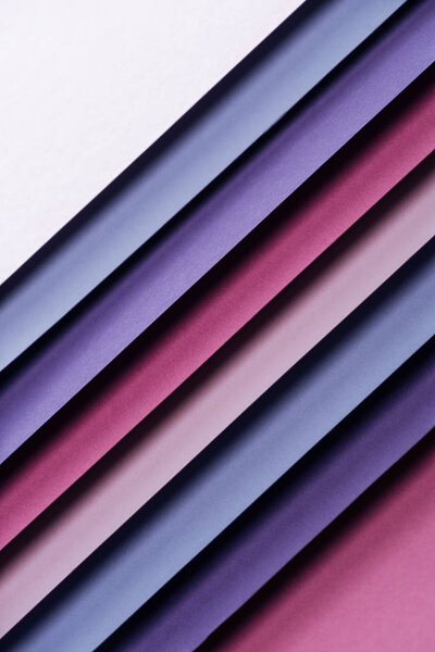 top view of blank blue, white, burgundy, pink and purple sheets of paper on pink background 