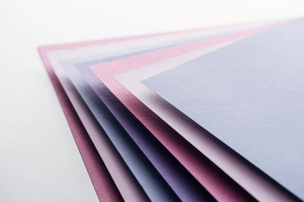 blue, white, pink and purple sheets of paper on white background 