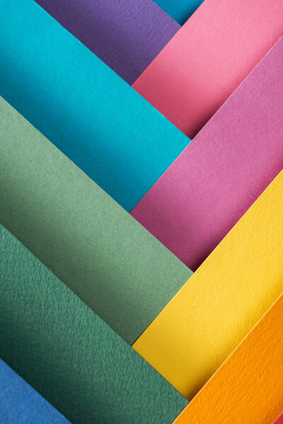 top view of blue, orange, burgundy, green, yellow, pink and purple sheets of paper 