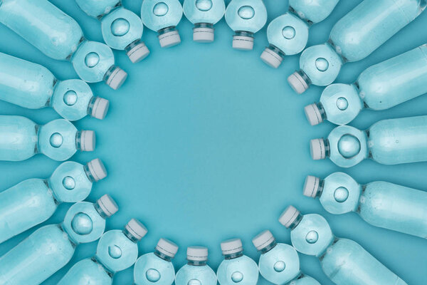 top view of round frame made of plastic water bottles isolated on turquoise with copy space