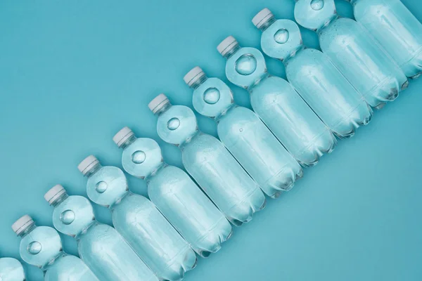 Top View Plastic Water Bottles Row Isolated Turquoise — Stock Photo, Image